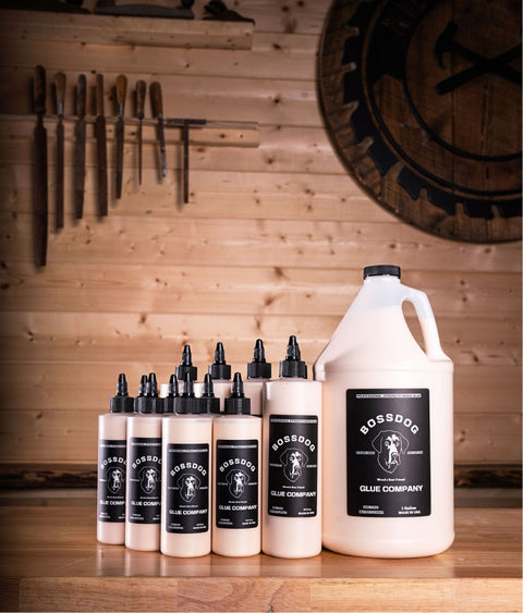 Multiple sizes of BOSSDOG wood glue bottles on table top in workshop