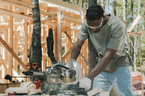 Man cutting wood with power tool at construction site