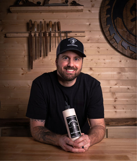 Photo of Nick Starrett holding bottle of BOSSDOG wood glue in workshop